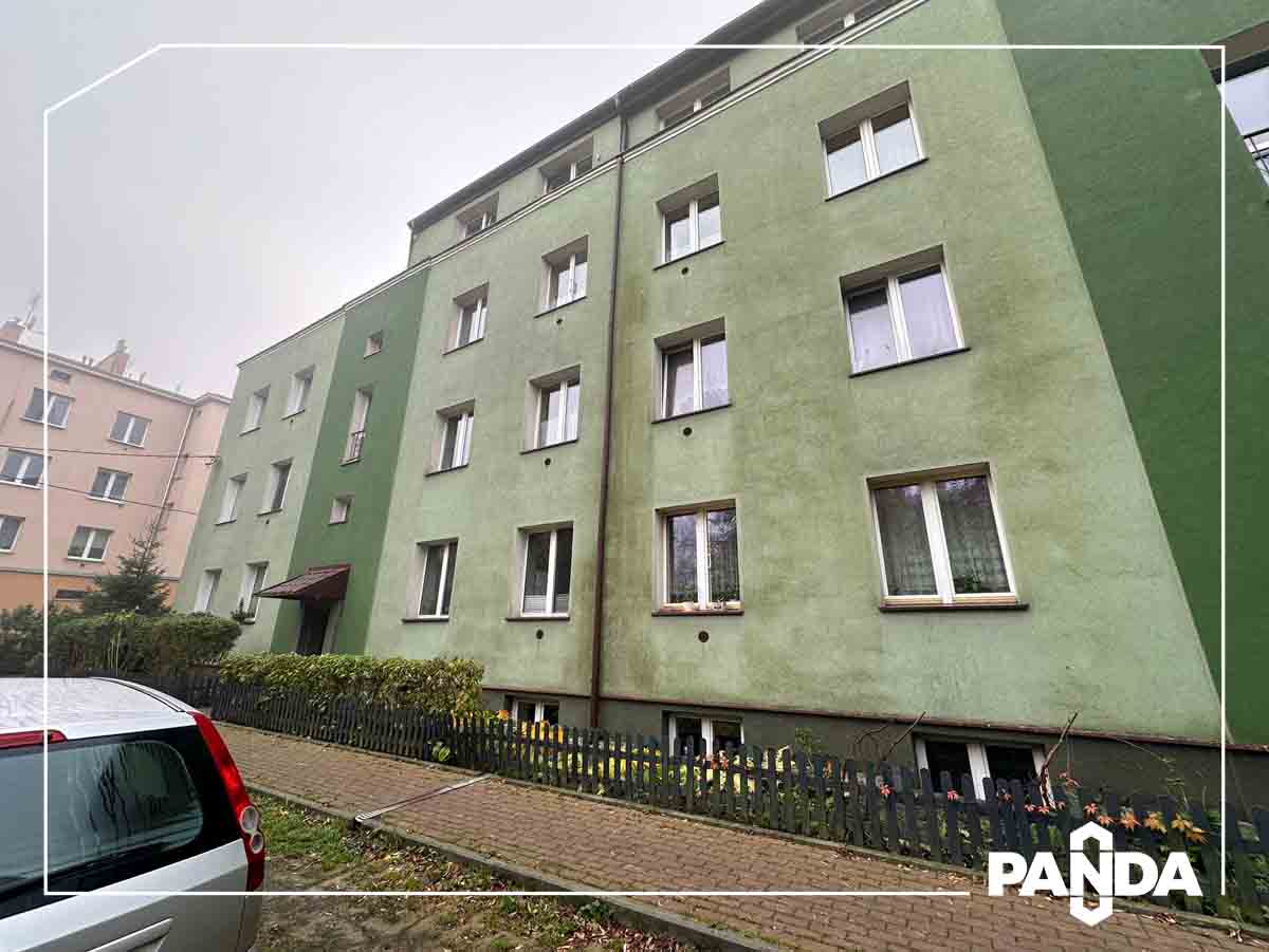 Brudny blok przed myciem elewacji Fasada bloku mieszkalnego pokryta ciemnym osadem i mchem przed czyszczeniem ciśnieniowym